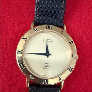 Gucci Gold Bezel Watch with Black Strap